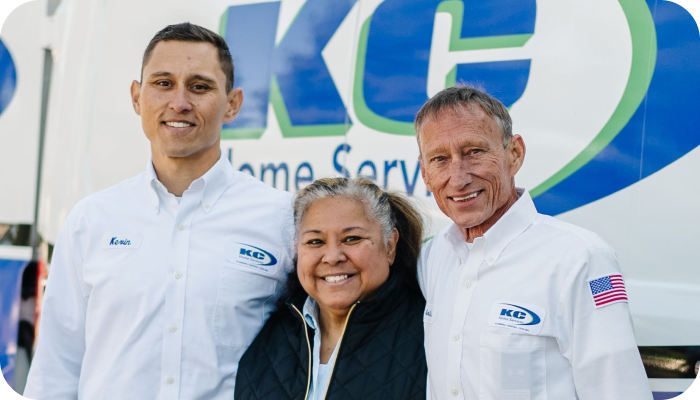 three people smiling together in an embrace