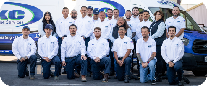 a group of people kneeling and smiling in front of a truck