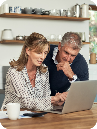 older couple looking at a laptop together in the kitchen