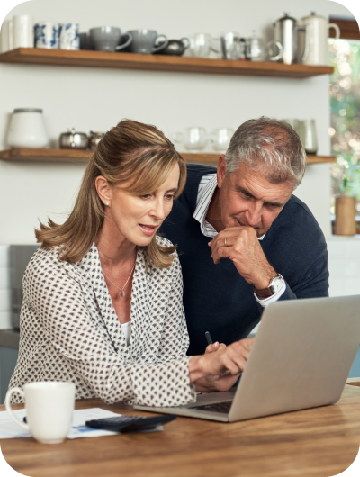 older couple looking at a laptop together in the kitchen